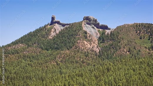 70mm cinematic aerial drone shot of Chimney Rock near Owl Creek Pass in Uncompahgre National Forest, near Pagosa Springs, Colorado, framed by rugged alpine terrain and jagged peaks.