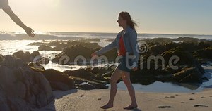 Man Giving Helping Hand To Woman on Beach 4k Stock Footage - Video of people, activity: 140539700