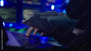 Closeup hand male hacker hacking into security systems. He typing on laptop keyboard and breaking password.