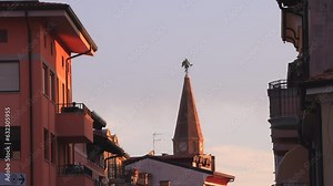 Bell tower with Statue portraying St. Michael and known as the Anzolo in Grado at the top of The Basilica of Sant'Eufemia, Friuli-Venezia Giulia - Grado, Italy