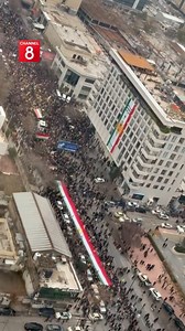 A female officer piloting a helicopter over Sulaymaniyah, capturing the view of a large demonstration in solidarity with the Rojava people. | Channel8 English