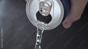 Canned water. Closeup on water pouring from opened aluminum can.