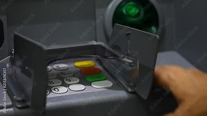 ATM close-up and the user's hand with a plastic card