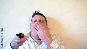 men who watches tv with a remote control in his hand.