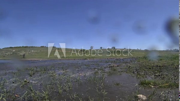 Riverfront controlled explosion drill.A tactical team executes a controlled explosion near a wide riverbank. Filmed from a protected observation zone, the blast sends debris outward.