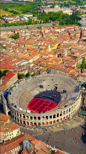 Vertical video. Verona, Italy. Flying over the historic city center. Arena di Verona, summer. Aer...