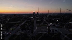 Wide drone shot of downtown Omaha Nebraska before the sun starts to rise for the morning. Drone rises up showing the radio towers and downtown buildings.