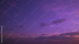 A colored evening sunset sky with a brilliant glow. The sun shines through the clouds and creates a purple gradient. At sunrise, a colorful heaven with solar rays streaming through the cloudscape.