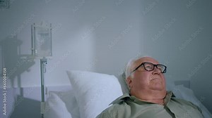 Old man patient laying down on the hospital couch he have a checkup he measure on the finger heart rate monitor pulse oximeter showing pulse