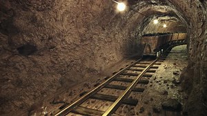 Coal mine carts or wagons slowly moving through narrow underground tunnel.