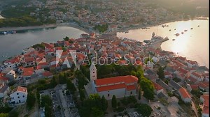 Primosten, Croatia - 4K flying above the famous traditional old town and peninsula of Primosten by the Adriatic sea in Croatia with a warm summer sunsrise