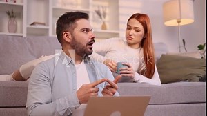 Smiling young couple looking at laptop computer screen choose products in online internet store make order online booking or plan trip at cozy home Happy people enjoying time together indoors