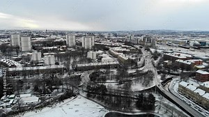 Aerial drone footage of Glasgow, Scotland, following snowfall. A park, roads and flyovers are in foreground, with city skyline behind.