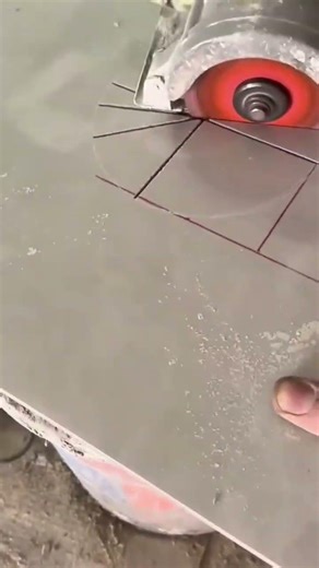 cutting grey ceramic tile into a star pattern using a specialized tool to create a round opening
