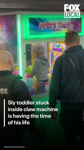 Smiling toddler gets stuck inside claw machine while parents aren't looking