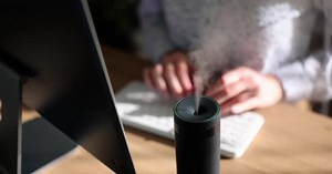 Woman Types Keyboard Computer Wooden Table While Diffuser Spreading Fragrance