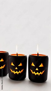 Flickering jack o' lantern candles cast a haunting glow against a simple white backdrop, enhancing the festive spirit of halloween celebrations with their warm light
