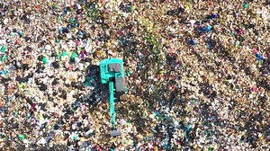 Aerial top view of A Huge Waste, garbage, dump, rubbish landfill. A landfill compactor, group of workers sort out the garbage in the landfill. Trash trucks dump waste polluting products