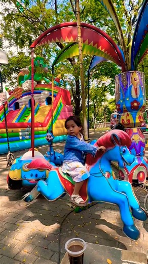 Riding the red-tailed blue horse and yellow airplane on the mini merry-go-round