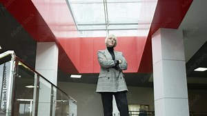 A bottom view slow motion close up shot of a female executive looking eagerly somewhere forward folding her arms on her chest