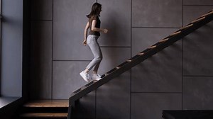 Young woman go up on the stairs on the home