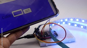 Breadboard circuit with a development board and LED strip connected using the phone as a control unit to change the color of LED . IoT project