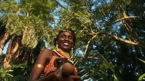 African Woman In Traditional Clothes In The Jungle Of Uganda - Low Angle, Close Up