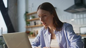 Nervous lady ceo videocalling by laptop dissatisfied documents at home closeup