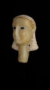 With her blue eyes and stylized hair, this sculpted woman’s head is a triumph of ancient Yemeni artistic skill. This remarkable alabaster funerary head discovered in the cemetery of Timna in 1951 is one of the best preserved objects from ancient Yemen. Her softly cascading braids are made from plaster, and the two holes at the ends of her hair may have served to hold a necklace. Her eyes are inlaid with a blue material, perhaps glass or lapis lazuli. Funerary heads such as this one were meant to