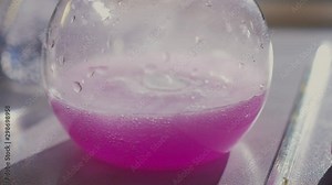 florence flask with purple liquid on table in laboratory