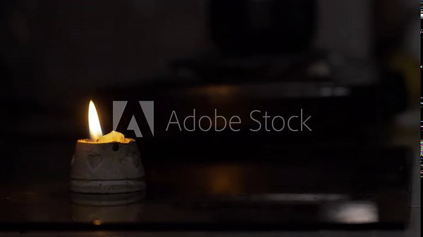 lighted candle in the dark, candle lights up a room with unfocused background