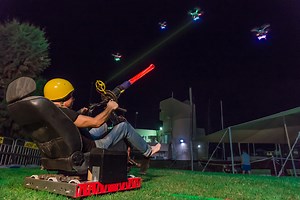 A Real Life Version of Space Invaders Made Using Drones, a Motorized Chair, and a Giant Laser