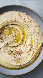 Opskrift: Hummus🧑‍🍳 Hjemmelavet hummus er en fantastisk måde at få flere bælgfrugter ind i hverdagsmaden. Den er både nem at lave og kan bruges i et væld af retter: i pitabrød, som dip til grønt, på rugbrød, i salater eller som en lille mellemret på tapasbordet. Det bliver dog ofte en lidt kompakt fornøjelse. Her slår vi et slag for en fløjlsblød, cremet og luftig humus, som den ville blive lavet af profferne. Det kræver lidt omhu – og nogle isterninger – men det tager kun 10-15 minutter, hvis