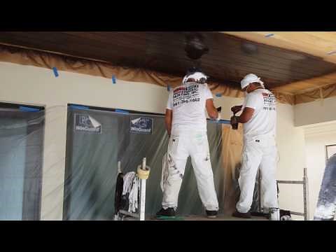 Spraying wood stain on cypress ceiling
