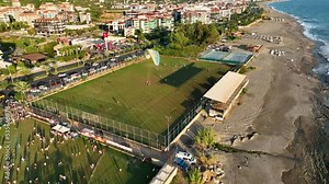 Happy crowd throwing color paint powder in air, festival atmosphere.