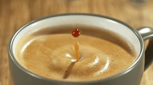 Super slow motion of falling drop into coffee with camera motion. Filmed on high speed cinema camera, 1000fps placed on high speed cine bot.