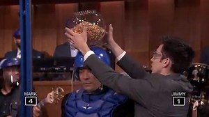 1.9M views · 3K reactions | Jimmy and Mark Wahlberg take turns shooting random objects off each other's heads with arrows in a new game called Headshots! | The Tonight Show Starring Jimmy Fallon | Facebook
