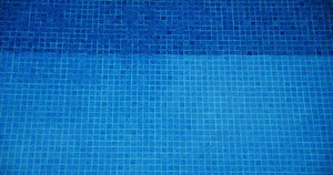 Blue water swimming pool top down static view. Relax chill out vacation sport recreation background. Aqua ripple. Small tiles.