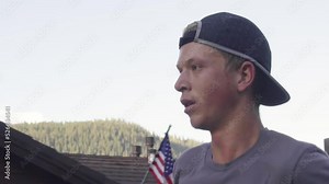 close up shot of professional runner face during a training marathon 5k run in 4k shot in slow motion. Attractive young man with backwards hat in truckee california, near lake tahoe
