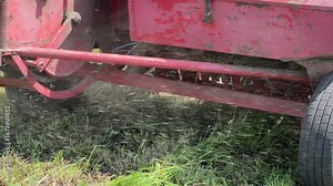 Baling hay with small square baler on a field