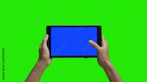 Tablet in the hand close up isolated at green background. Tablet screen is blue chroma key, background chroma key green screen. Footage for Tablet ads, app promo.