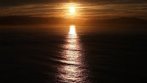 clip-1010037608-full-moon-rising-over-ocean-horizon-night
