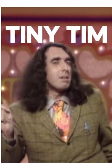 Tiny Tim, nombre real Herbert Khaury, nació en Nueva York en 1932 y creció en pobreza durante la Gran Depresión. Desde joven tuvo problemas de salud física y mental, incluyendo escoliosis severa que le causó dolor crónico durante toda su vida. Alcanzó fama mundial en 1968 con la canción “Tiptoe Through the Tulips”, impulsada por el programa Rowan & Martin’s Laugh-In. La exposición fue inmediata, pero también lo fue el encasillamiento. La industria y el público lo trataron más como un personaje q