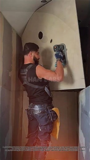 Professional tilers install large-format wall tiles using advanced techniques.