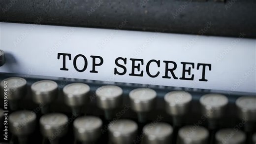 Feeding sheet, vintage typewriter typing TOP SECRET to label file at desk, blurred keytops
