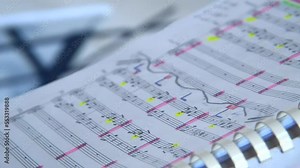 Book with score for orchestra. Conductor's notes. Notebook. Classical music for orchestra. Musical notation on paper. Music stand. School of Music