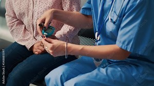 Nurse doing insulin level measurement with glucometer to help patient with diabetes, using instrument to check glucose and sugar from blood. Attending checkup appointment. Close up.