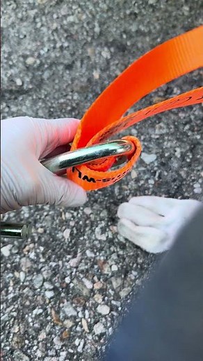 Attaching a sling to the hook when securing a load to the trailer. load securement, trailer loading.