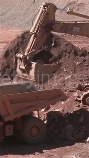 Digger loading truck at quarry