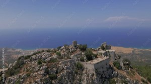 Aerial 4K landscape view of medieval Kantara Castle which is located at the Mountains in North Cyprus. Medieval Castle is surrounded with rocks & trees with an amazing view of Mediterranean Sea.